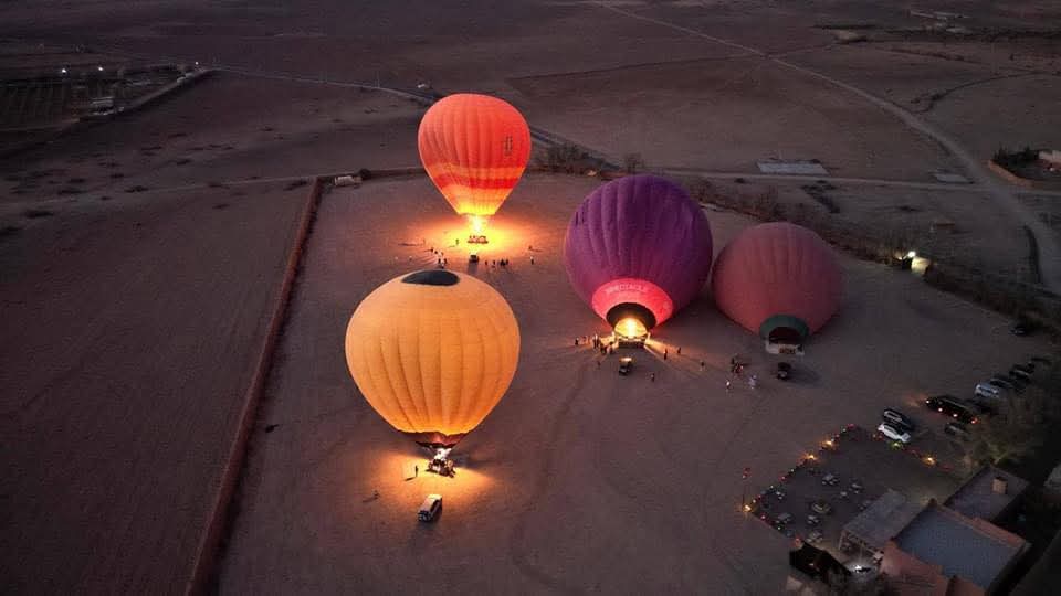 Illuminated hot air balloons on ground preparing for night flight