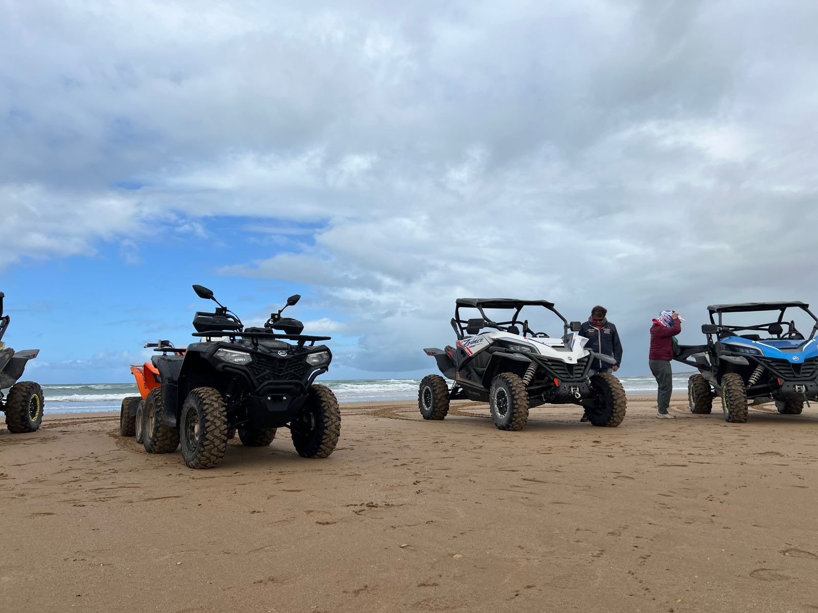 Line of ATVs and buggies on sandy beach