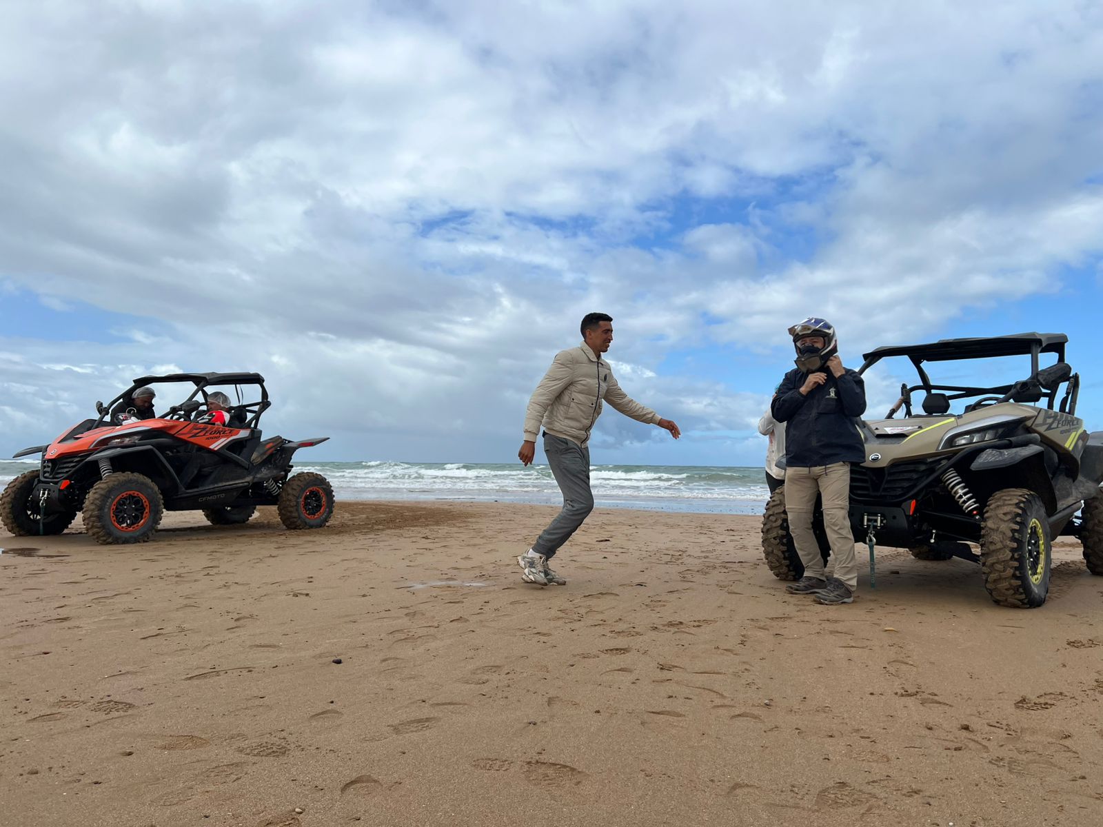 Person jumping with joy next to buggies on beach