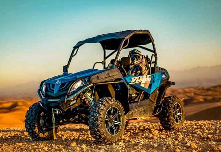 Blue buggy at golden sunset in desert