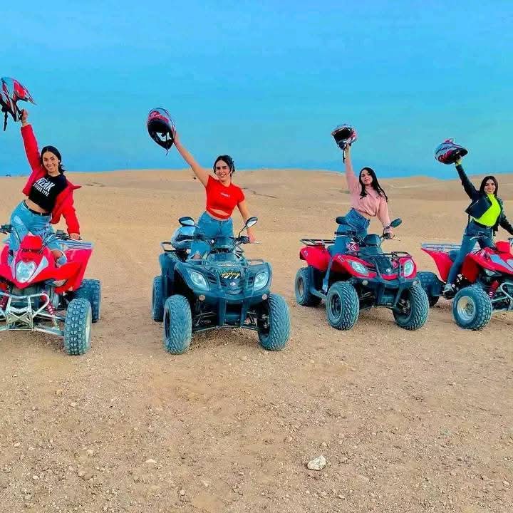 Group of women on quad bikes in desert